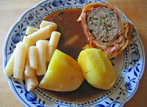 Hackbraten im Blätterteig mit Schwarzwurzelgemüse und Kartoffeln auf Zwiebelmusterteller